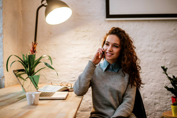 istock Young smiling woman talking on phone in modern office interior. 909762984