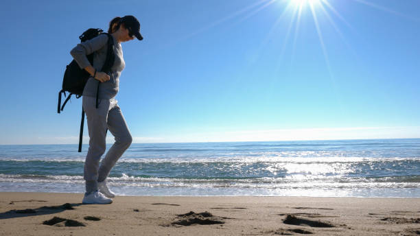 istock Young woman on holiday exploring nature on the beach 909765194