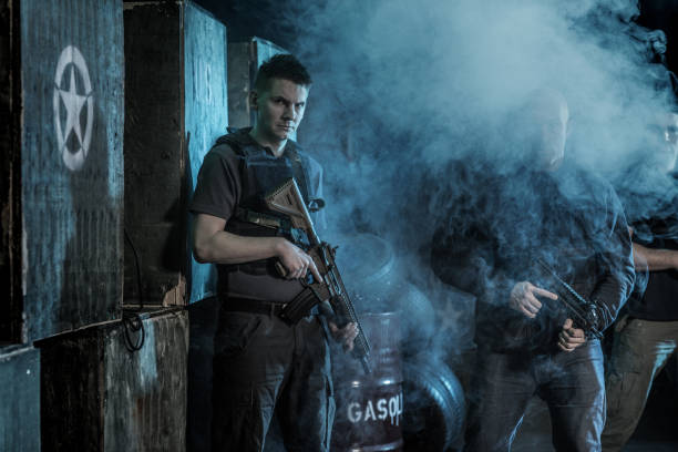 istock Krav Maga fighting group posing for team picture during training in dark indoor urban setting 909768158