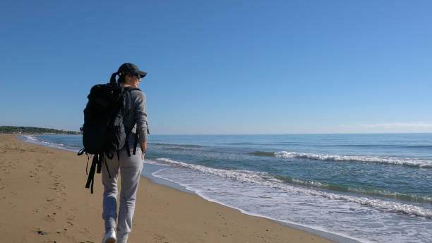 istock Young woman on holiday exploring nature on the beach 909768452
