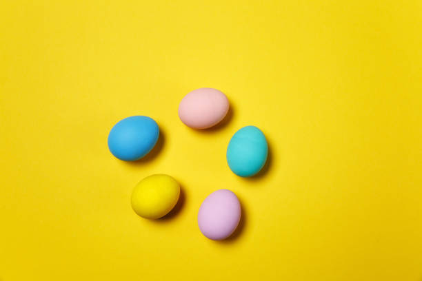 istock Five colorful pastel monophonic painted Easter eggs isolated on yellow background for card or postcard. Happy Easter concept. Copy space for advertisement. With place for text. Top view on eggs. 909772718