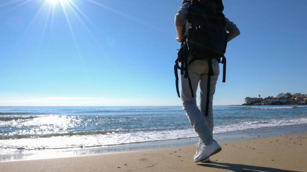 istock Young woman on holiday exploring nature on the beach 909775344