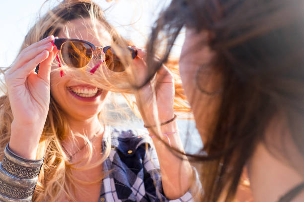 istock Friends looking through eyeglass used like a mirror 909778118