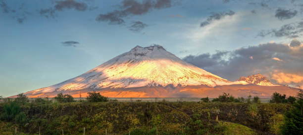 Cotopaxi volcano at sunset Cotopaxi volcano with sunset light shinning on it's slopes, and crops in the foreground, Ecuador. cotopaxi photos stock pictures, royalty-free photos & images