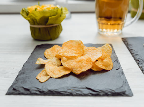 istock Beer and chips on the large white table 909788684