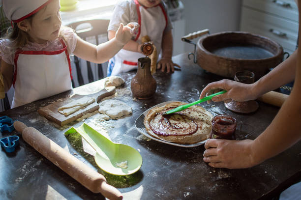 istock Young family cooking in kitchen. Teaching to bake pancake 909789172