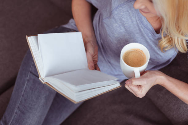 istock woman with book and coffee at home 909792012