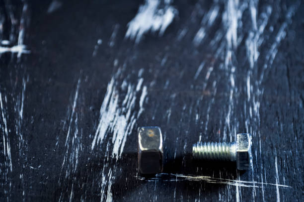 istock Nuts for repairs lying on a wooden table. Iron nuts and screws f 909795042