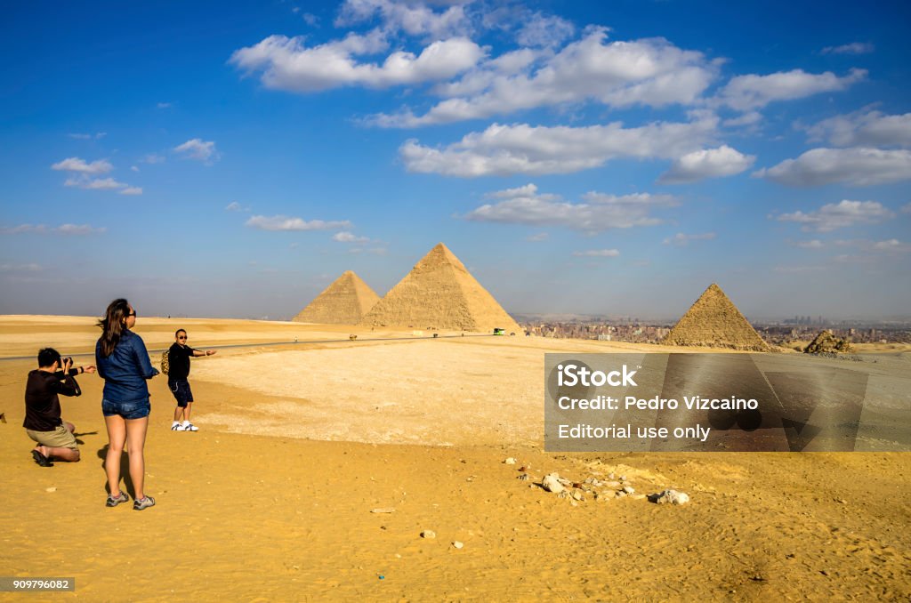 Chinese tourists in the Pyramids of Giza. Cairo, Egypt. CAIRO-DECEMBER 4, 2015: local Egyptians tourists are the majority at the Pyramids as foreign tourism dropped drastically. Chinese tourits are the big majority of foreign tourist at the Giza Pyramids. Adult Stock Photo