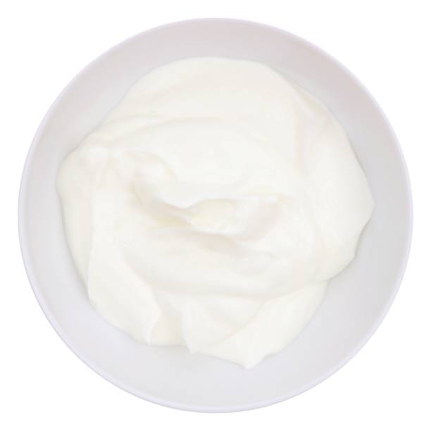 Greek yogurt in a white bowl, above view isolated on white Creamy Greek yogurt in a white bowl, above view isolated on a white background greek yogurt photos stock pictures, royalty-free photos & images
