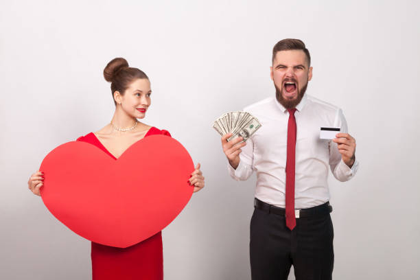 Angry man roar, his pays for love, woman smiling Angry man roar, his pays for love, woman smiling. Indoor, studio shot, isolated on gray background bellows stock pictures, royalty-free photos & images