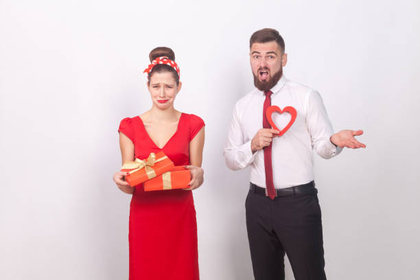 istock Disappointment. Woman holding gift box and cry, man confused 909798868