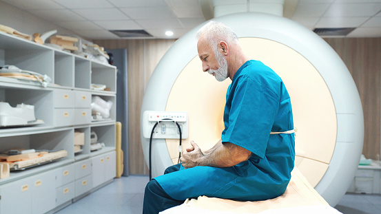 Closeup of a senior man at an MRI scanning clinic waiting to be examined and hoping for the best. His mind is full of doubts and uncertainty at the moment.