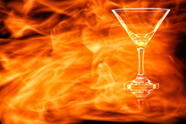 leere martini-glas in den flammen des feuers. - martini brand vermouth stock-fotos und bilder