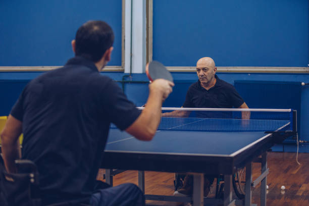 istock Man in a wheelchair is playing table tennis 909814154