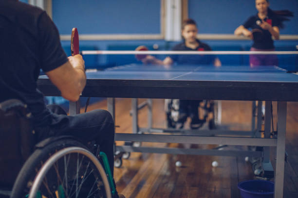 istock Young boy in wheelchair playing table tennis 909814476