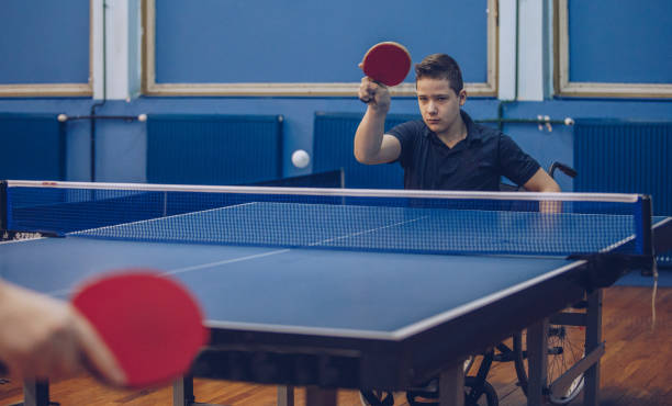 istock Boy in wheelchair playing table tennis 909816736