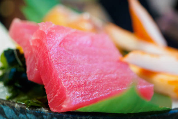 istock Sashimi set on ice with salmon tuna with chopsticks 909817278