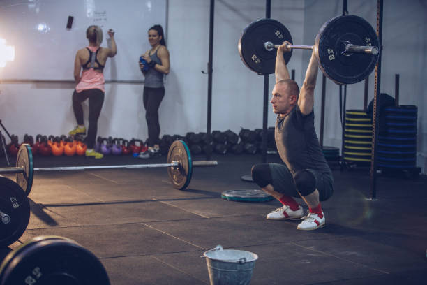istock Sporty man lifting weights in the gym 909817522