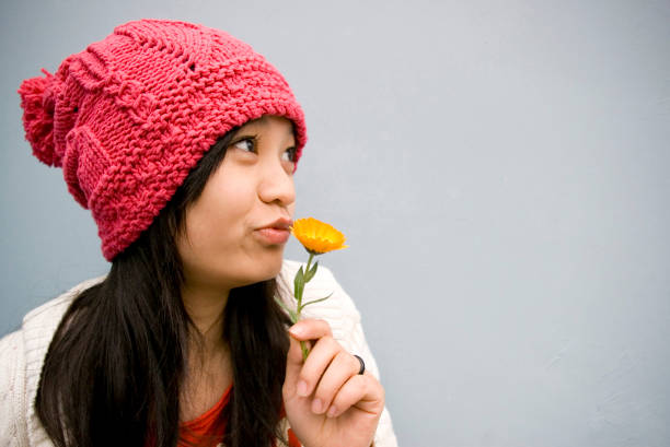 Beautiful woman portrait smelling a flower