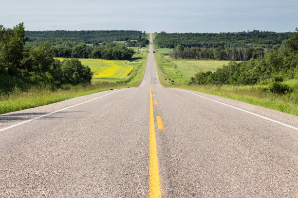 istock long straight highway going into the distance up a hill 909828322