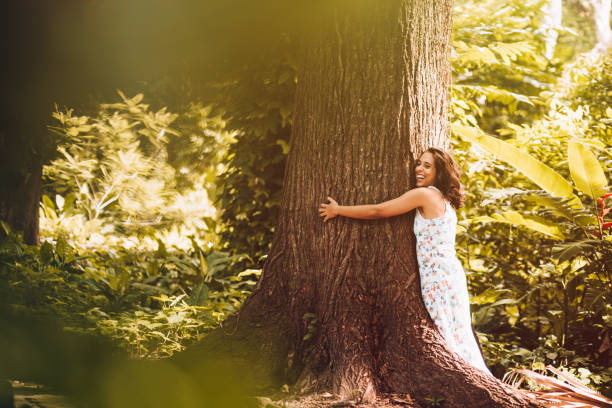 istock Young woman hugging the tree 909828586