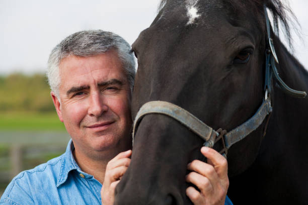 istock Mature man with horse. 909829030