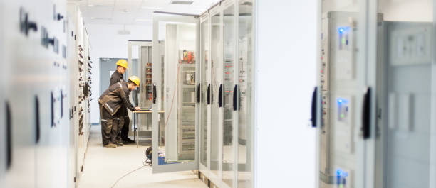 Field service crew testing electronics or inspecting electrical installation system Field service crew testing electronics or inspecting electrical installation system. Bay control unit. Medium voltage switchgear coupling stock pictures, royalty-free photos & images