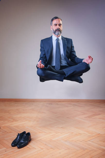 empresário de ioga flutuando no ar - lotus position - fotografias e filmes do acervo