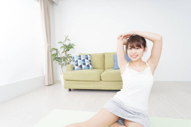 woman doing some stretches in room - stretching women attractive female indoors imagens e fotografias de stock