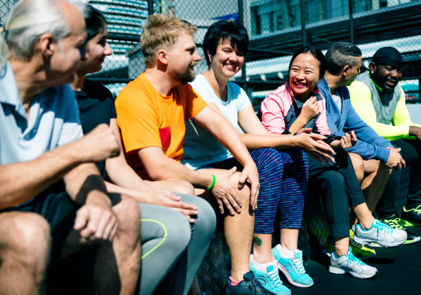 istock Group of diverse athletes sitting together 909847162