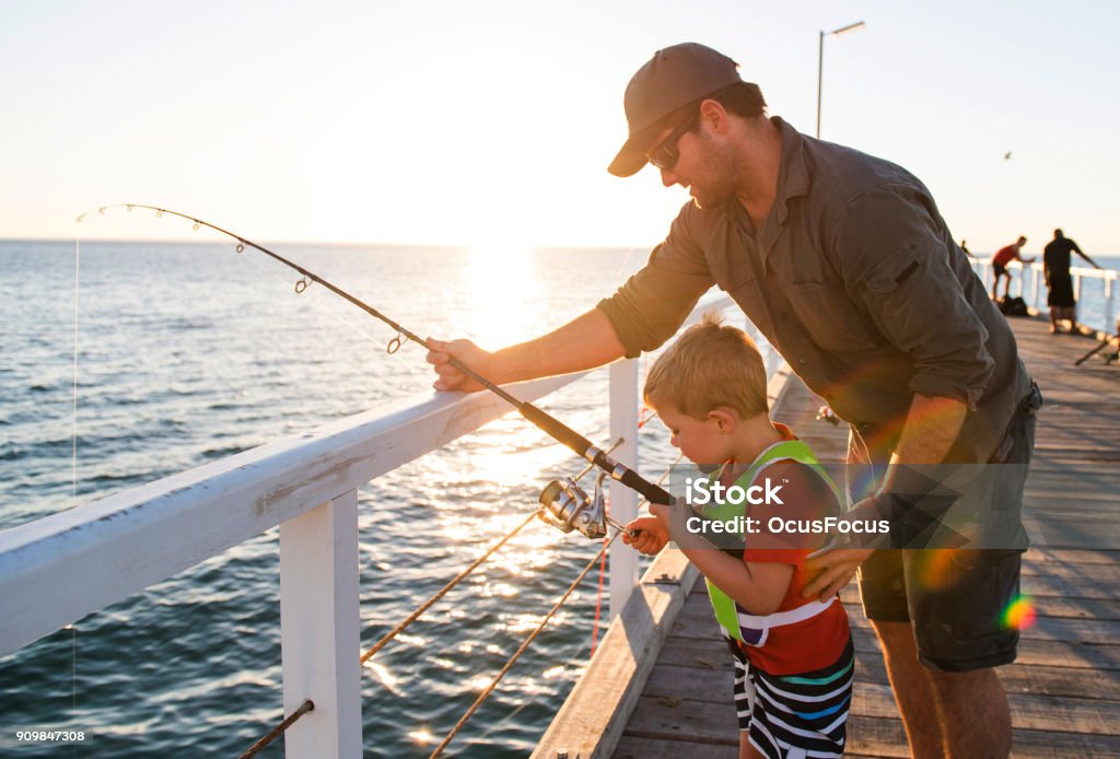 mutlu Amerikan baba birlikte denizde Balık tutma bir balıkçı olmak küçük oğlunun öğretim zevk ve güneşli bir yaz günü balık çubuk kullanarak öğrenme dolgu rıhtım - Royalty-free Balıkçılık Stok görsel