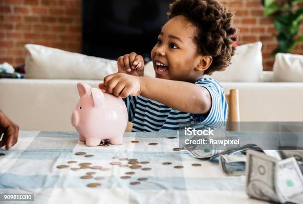 Muchacho Negro Que Recoge Dinero Para La Hucha Foto de stock y más banco de imágenes de Niño - Niño, Ahorros, Hucha cerdito