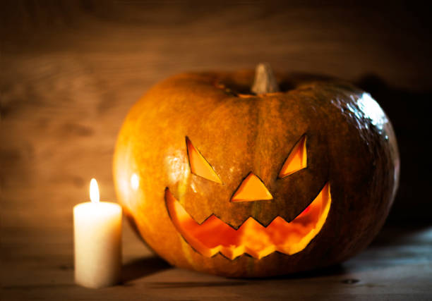istock Halloween pumpkin head jack lantern in the wooden background 909850964
