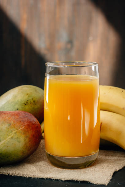 istock Mango and banana juice on black surface. 909851128