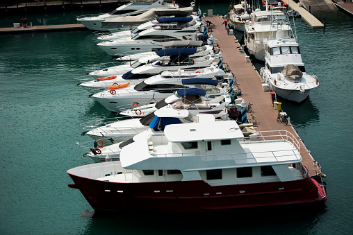 Yachts of different sizes are parked at the shore at the bay, selective focus