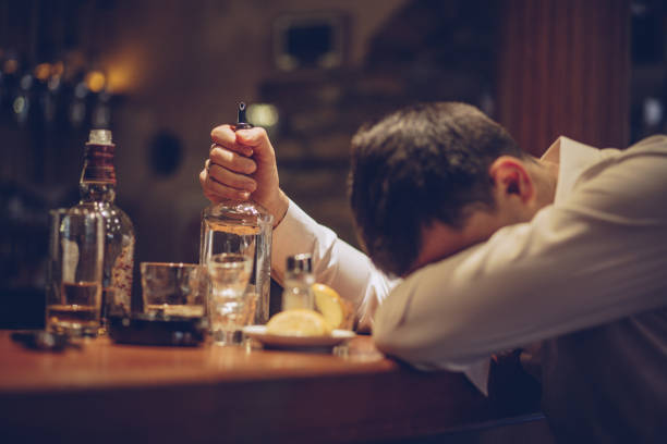 Heavy drinking in bar One man, sitting at the bar counter alone, he has drinking problems, sleeping on bar counter. drunk stock pictures, royalty-free photos & images