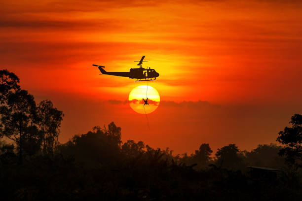 Soldiers rescue helicopter operations on sunset sky background