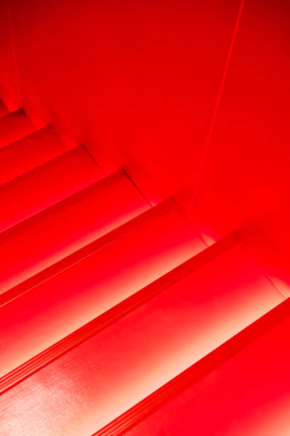 istock Abstract modern red stairs with warm light  - stairway composition 909857762