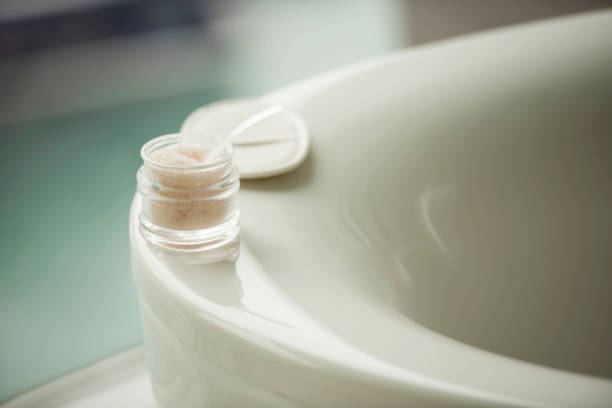 Beautiful round bathtub with mineral salt around in a jar, selective focus