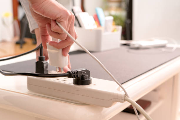 women hand hold the electric plug to putting on the electricity supply connection - electric plug outlet human hand electricity imagens e fotografias de stock