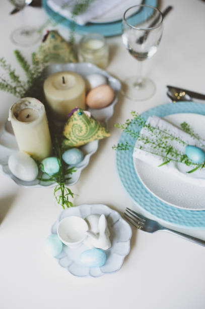 istock easter and spring festive table decorated in blue and white tones in natural rustic style, with eggs, bunny, fresh flowers and candles. 909870514
