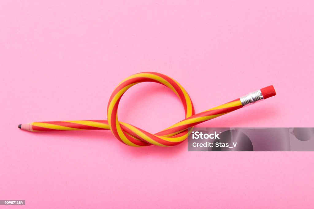 Flexible pencil on a pink background. Bent pencils two-color Flexibility Stock Photo