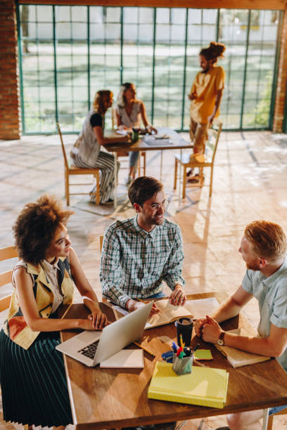 istock Above view of happy college students talking about the exams while studying together. 909874734