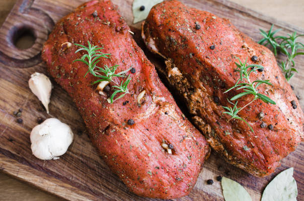 istock Fresh Raw Marinated Meat on a Wooden Table. 909877970