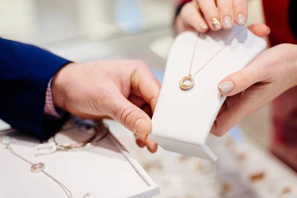 man buying necklace in jewelry store. - sales clerk imagens e fotografias de stock