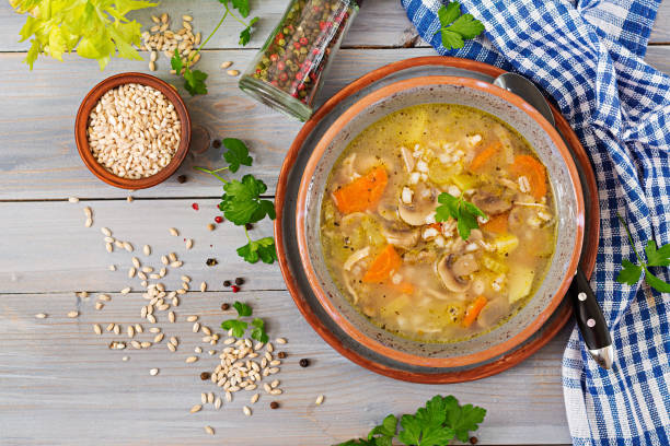 istock Thick soup with pearl barley, celery, chicken, and mushrooms. Dietary menu. Top view 909878708