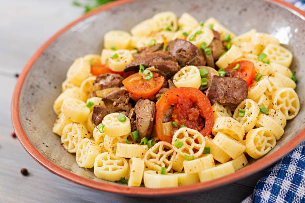istock Fried chicken liver with tomato and garnish of pasta 909879014