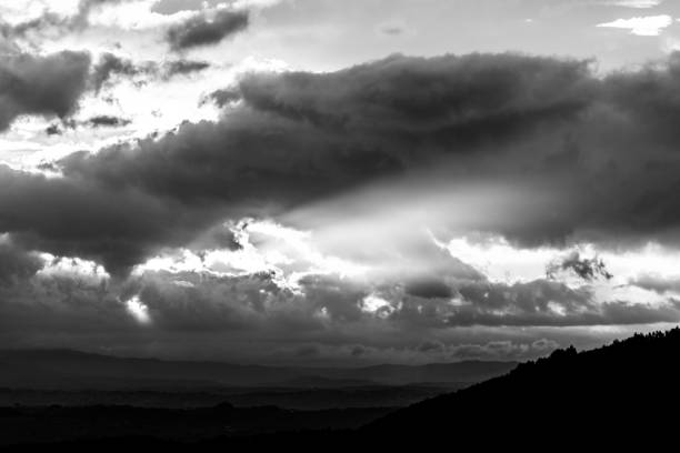 istock Sunset over a valley, with sun rays coming out through some clouds 909883084