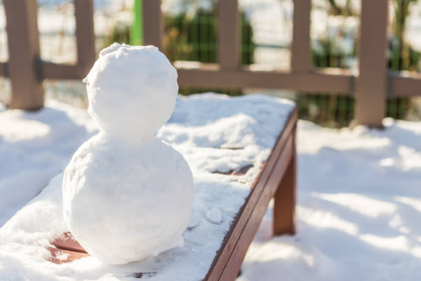 istock Snowman on the bench, cold winter 909883294